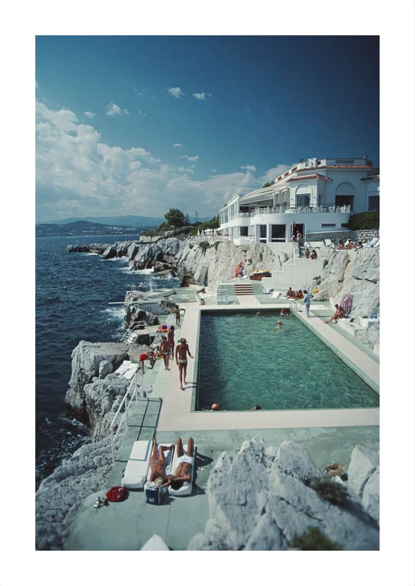 A hotel swimming pool and people beside the Mediterranean Sea.